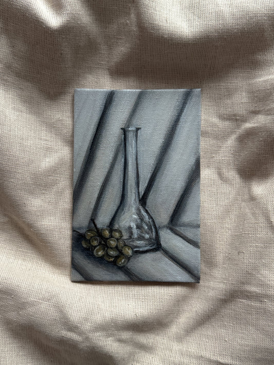 a glass bottle & grapes